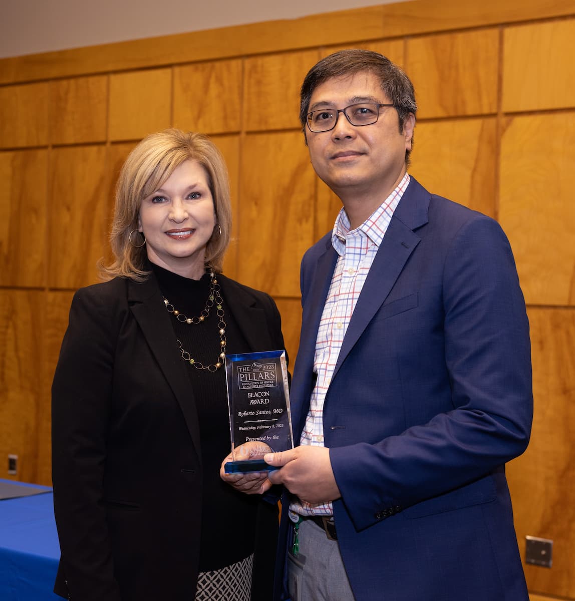 Dr. LouAnn Woodward, vice chancellor for health affairs and dean of the School of Medicine, congratulates Dr. Roberto Santos on winning the Beacon Award.